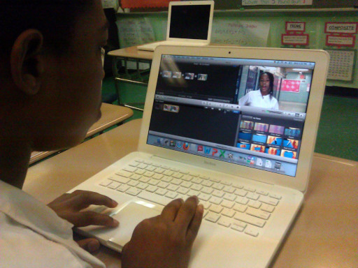 Middle school student edits a video on a laptop.