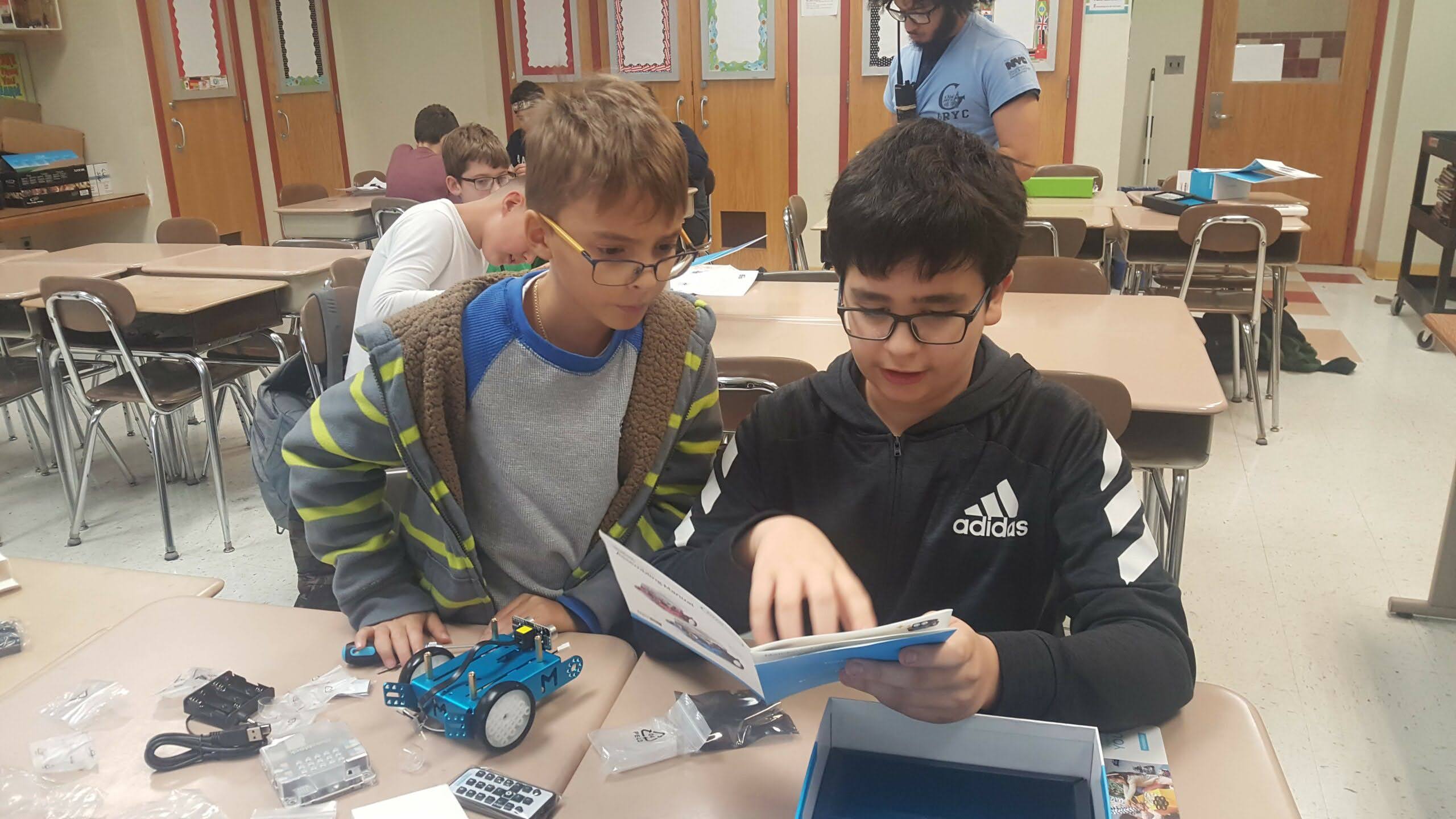 Two students learn how to build a robot.