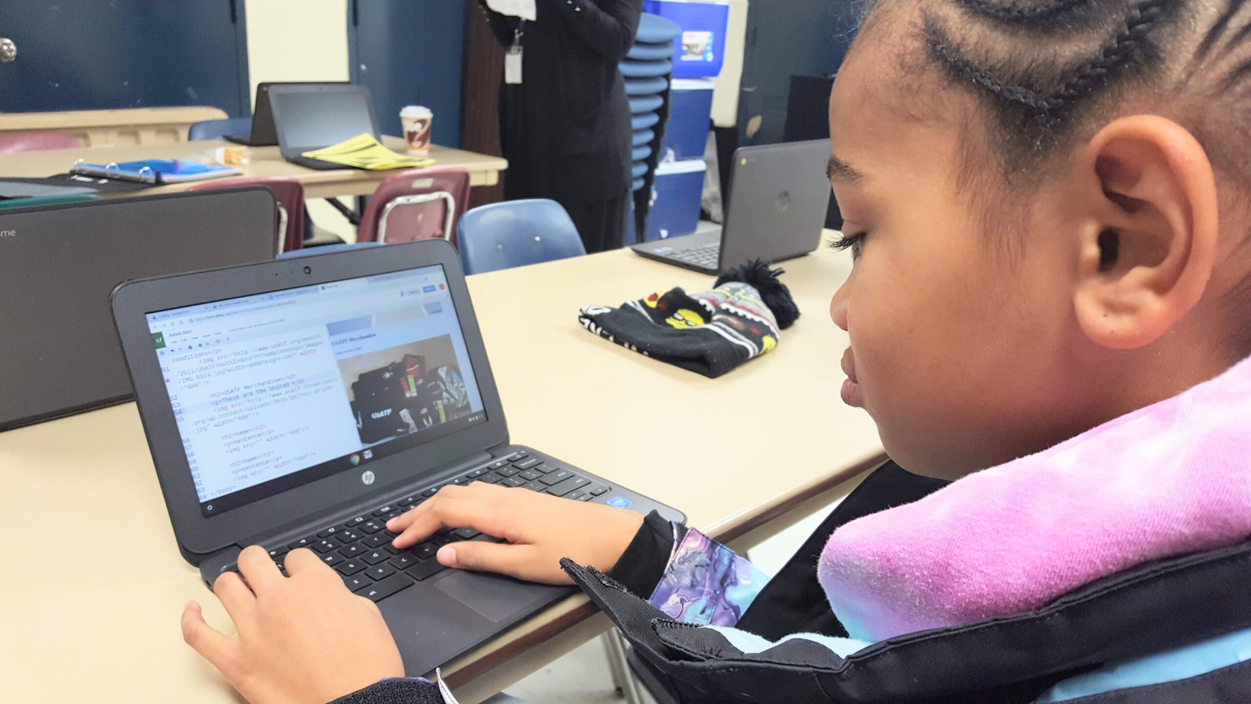 Girl codes her website on a laptop.