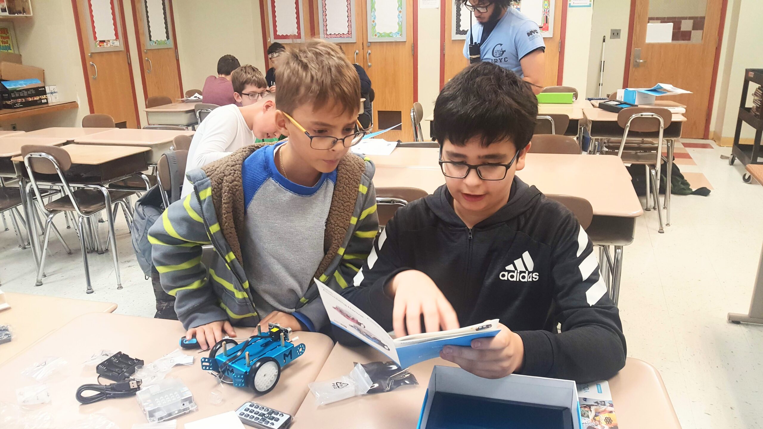 Two students learn how to build a robot.