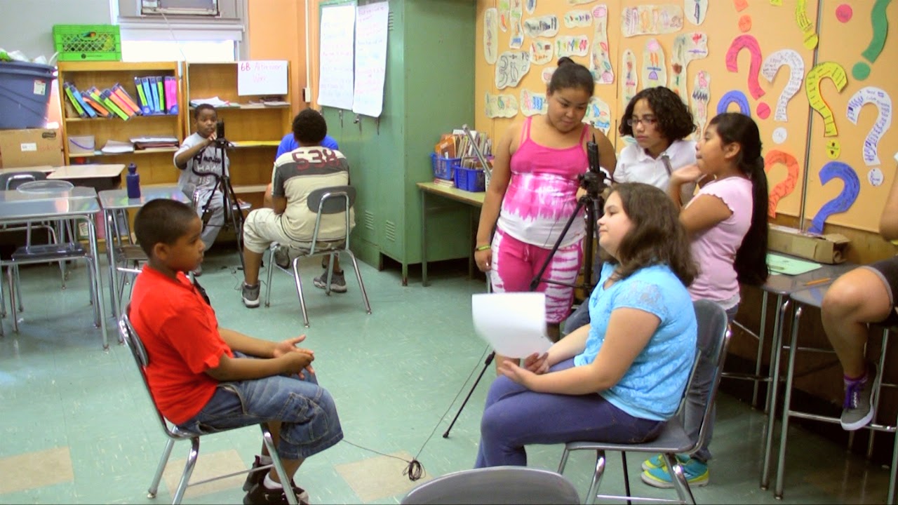 Two groups of students interview their classmates.