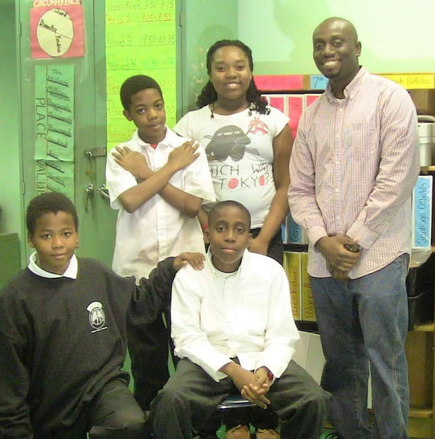 Four after school program students take a photo during journalism class with their instructor.