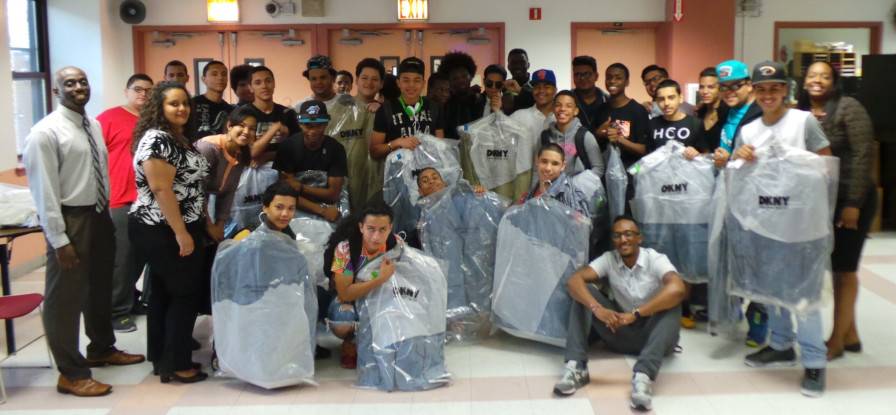 Large group photo for Dress For Success event with high school boys receiving a new sport coat from DKNY.